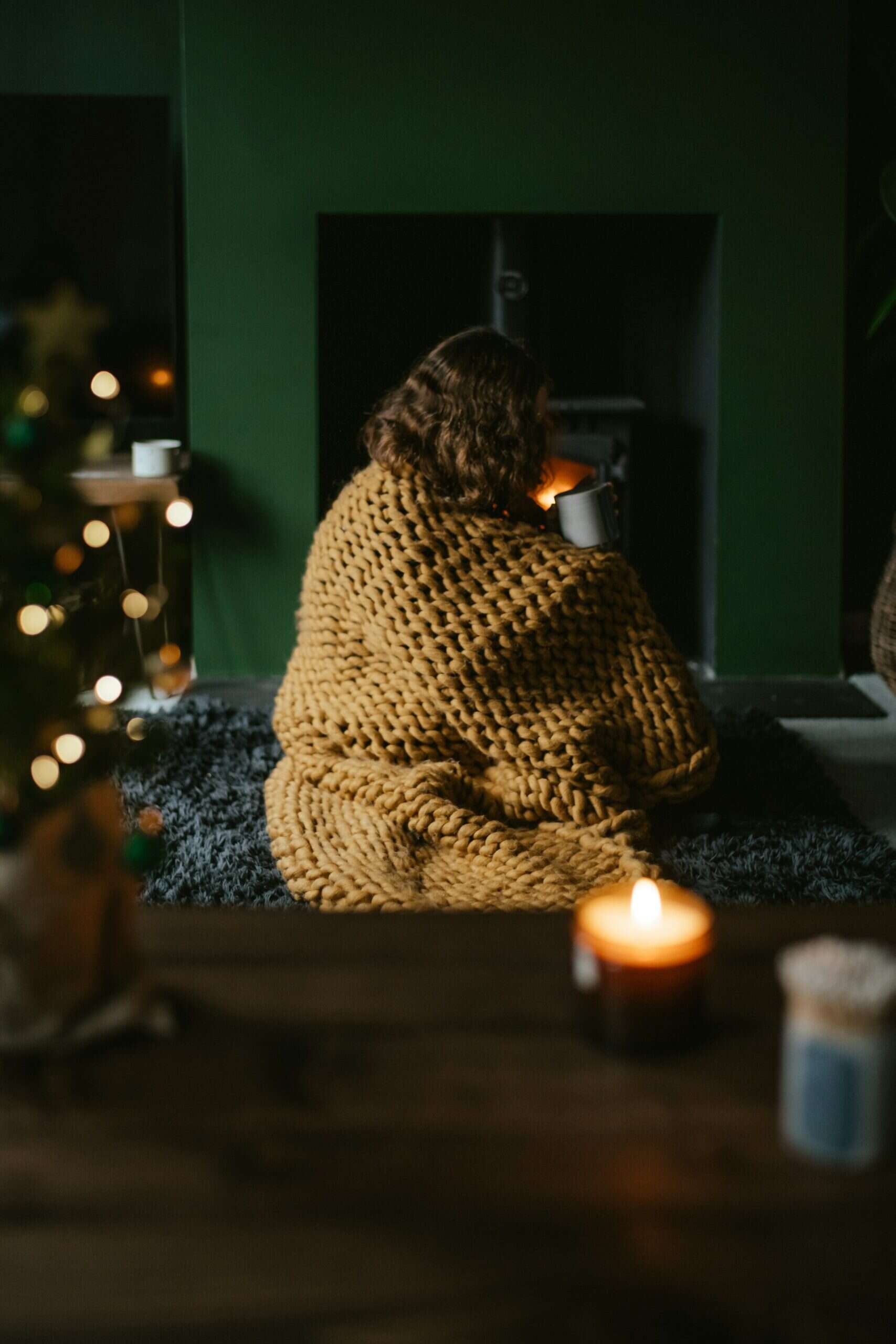 Woman wrapped in cozy blanket with candlelight practicing ADHD mindfulness practices for calm and focus