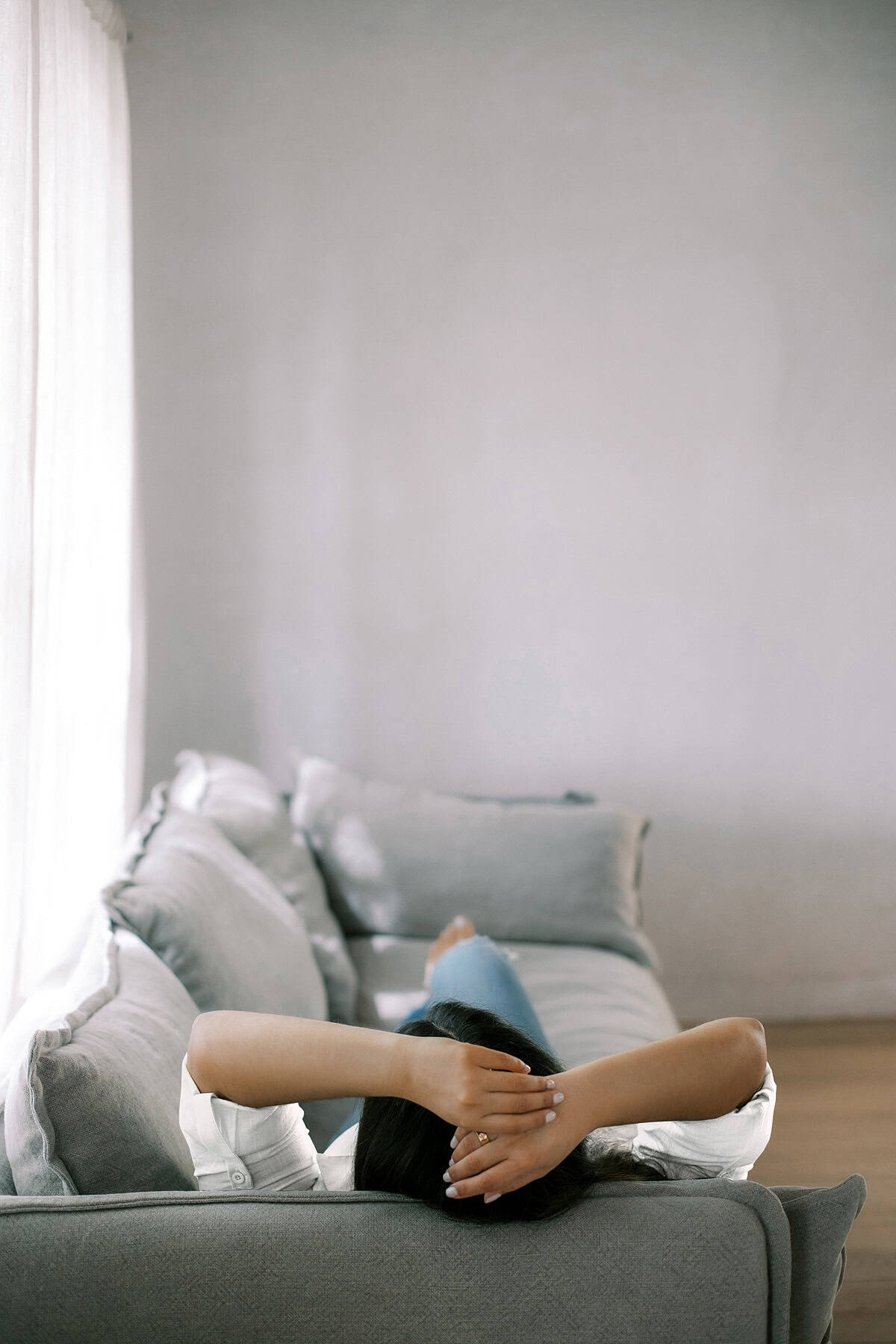 Woman lying on couch showing the benefits of being lazy and guilt-free relaxation.