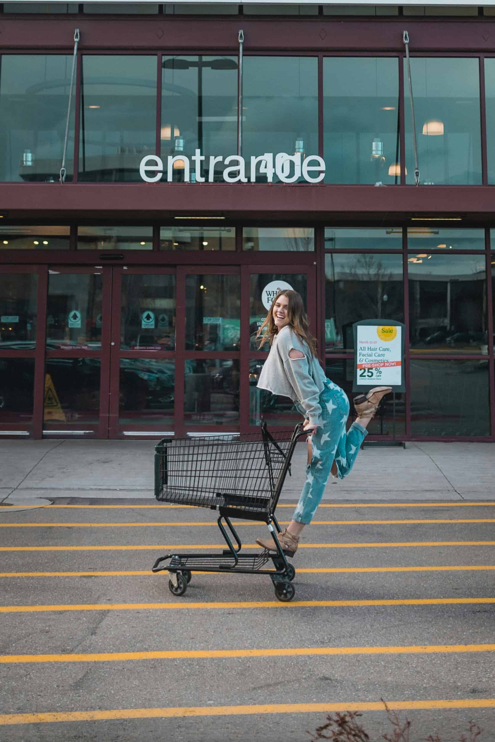 Smiling woman pushing shopping cart outside grocery store — ADHD shopping list made fun.