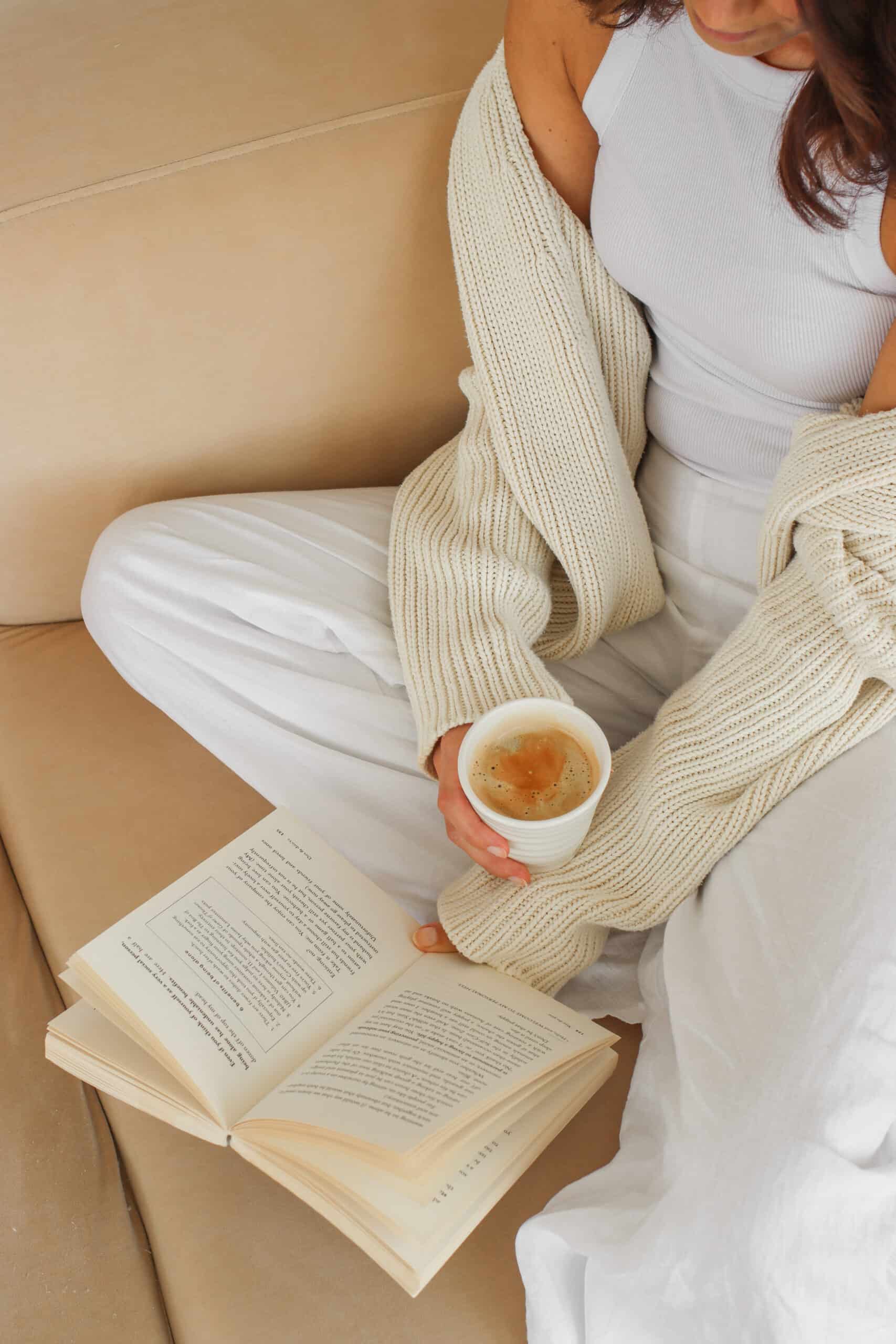 Cozy moment of a woman holding coffee and reading, illustrating gentle ADHD life hacks that support a calmer day.