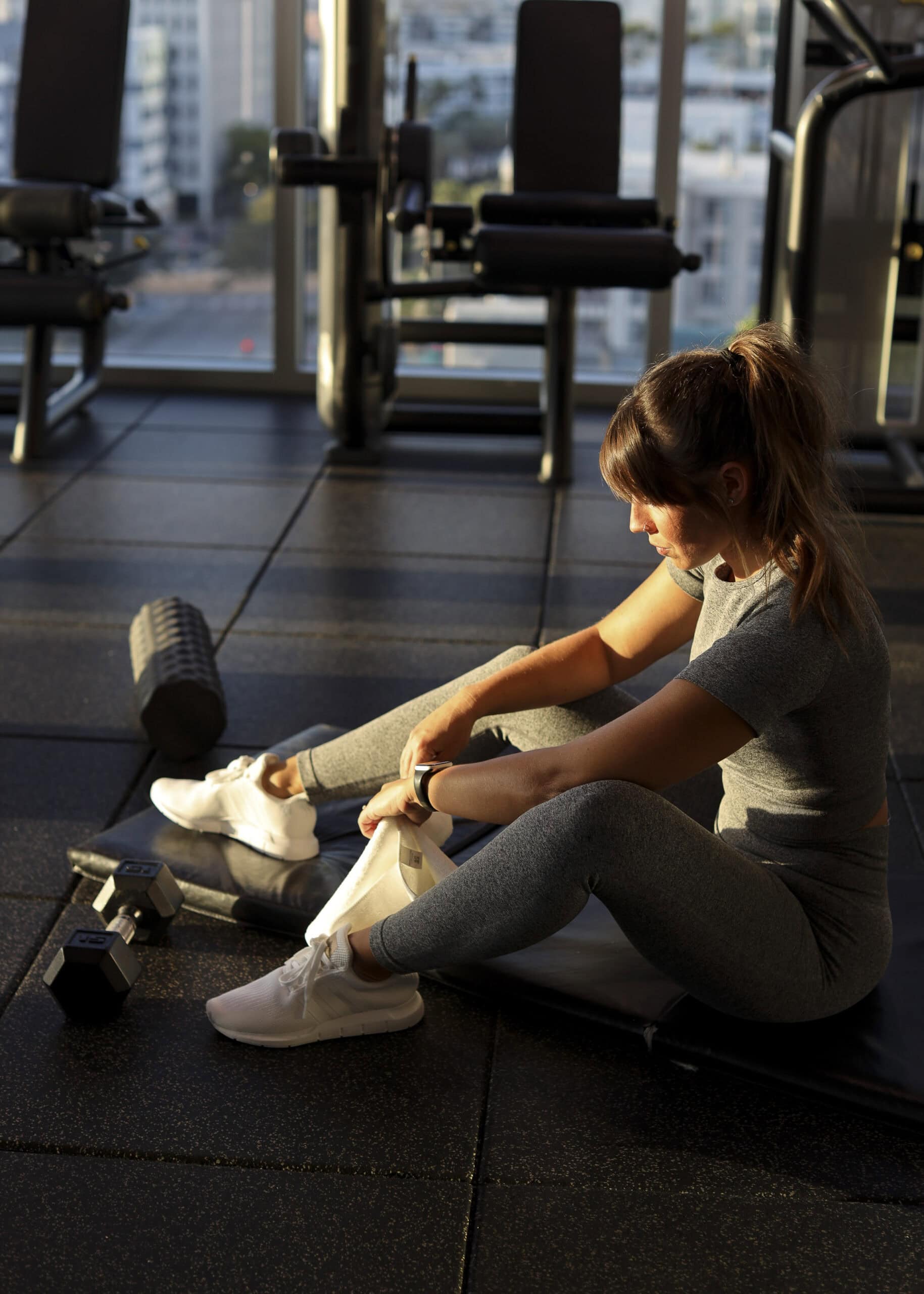 Woman resting after workout in morning light — ADHD lock-in and gentle commitment concept.
